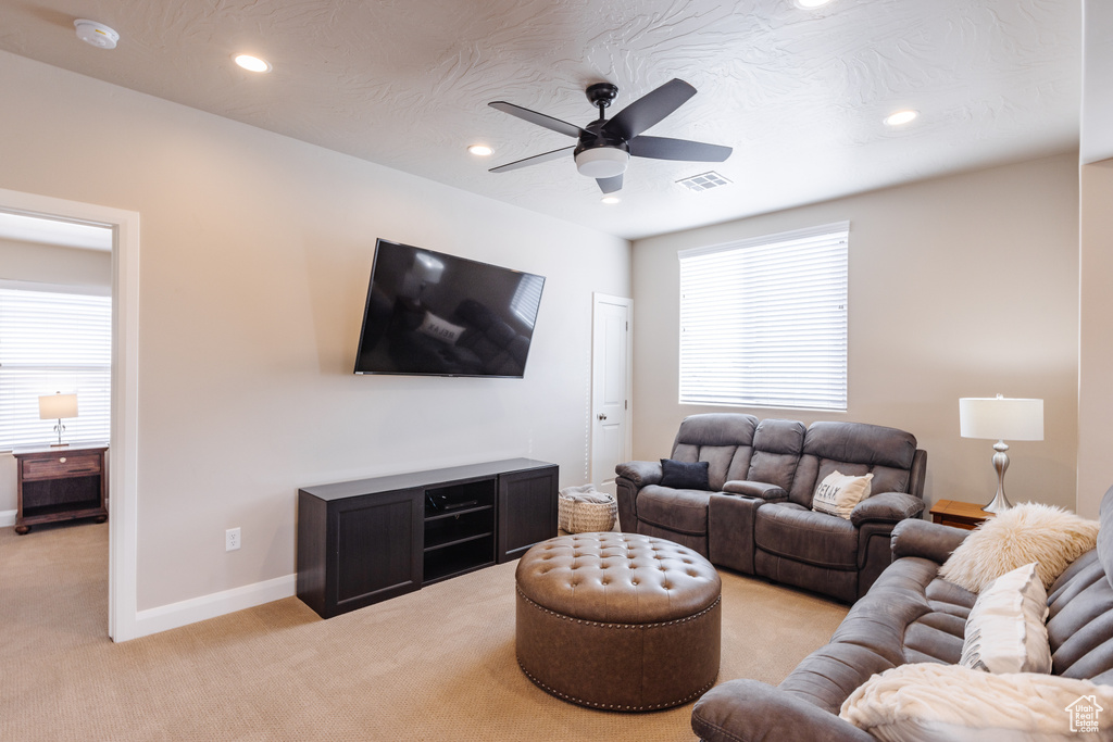 Living area featuring light colored carpet, ceiling fan, recessed lighting, and baseboards