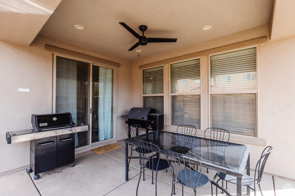 View of patio with outdoor dining space, ceiling fan, and area for grilling