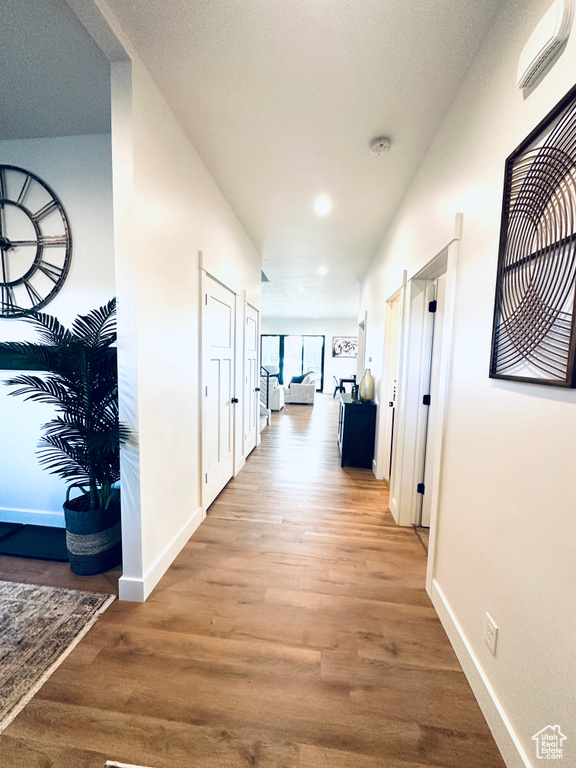 Hallway featuring wood finished floors, baseboards, and recessed lighting