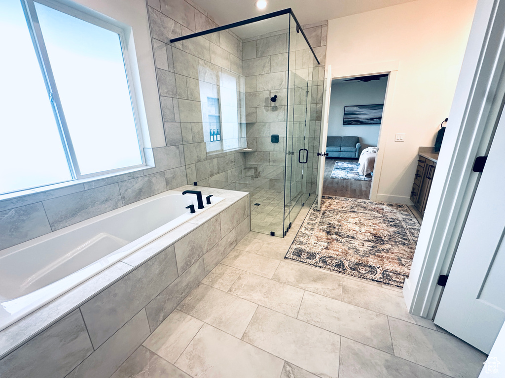 Full bathroom featuring a shower stall, ensuite bathroom, and a garden tub