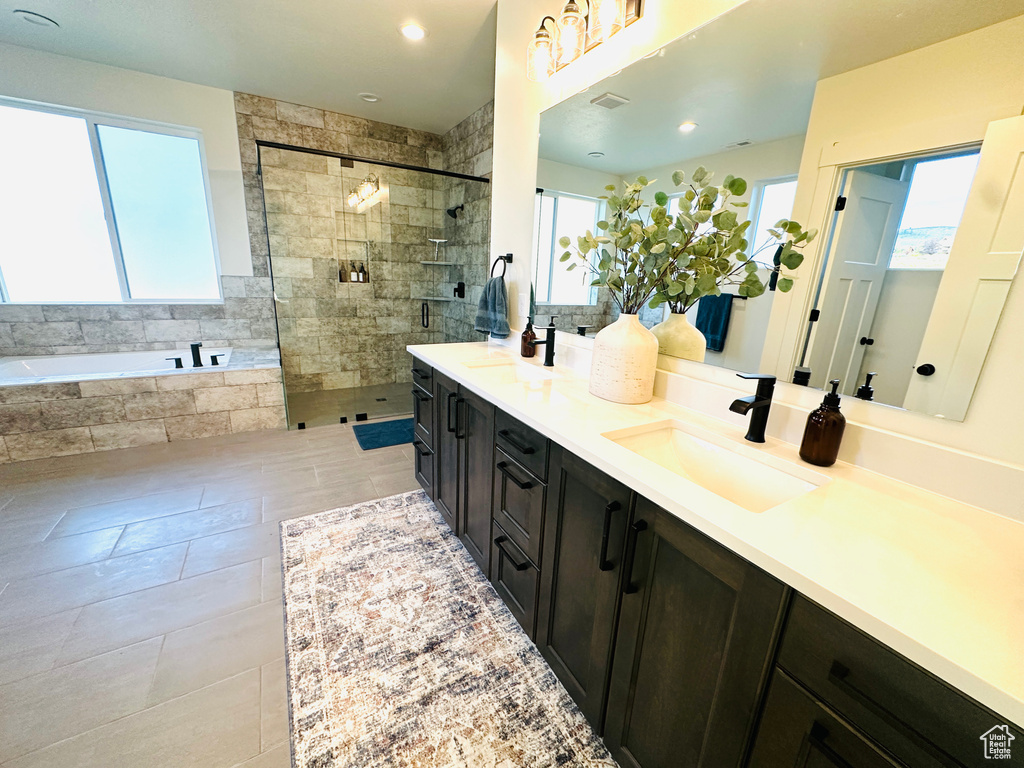 Full bath with a bath, a tile shower, tile patterned flooring, and double vanity