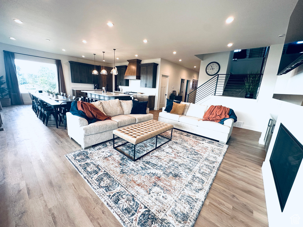 Living area featuring recessed lighting, light wood-type flooring, and stairs
