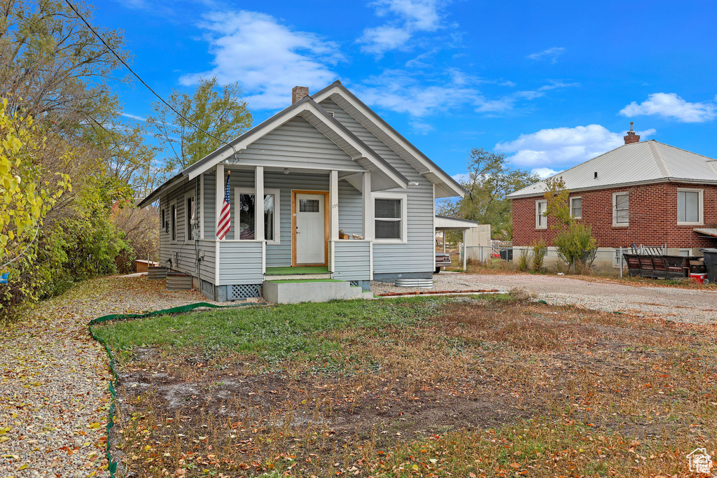 Shotgun-style home featuring a chimney, fence, and a porch