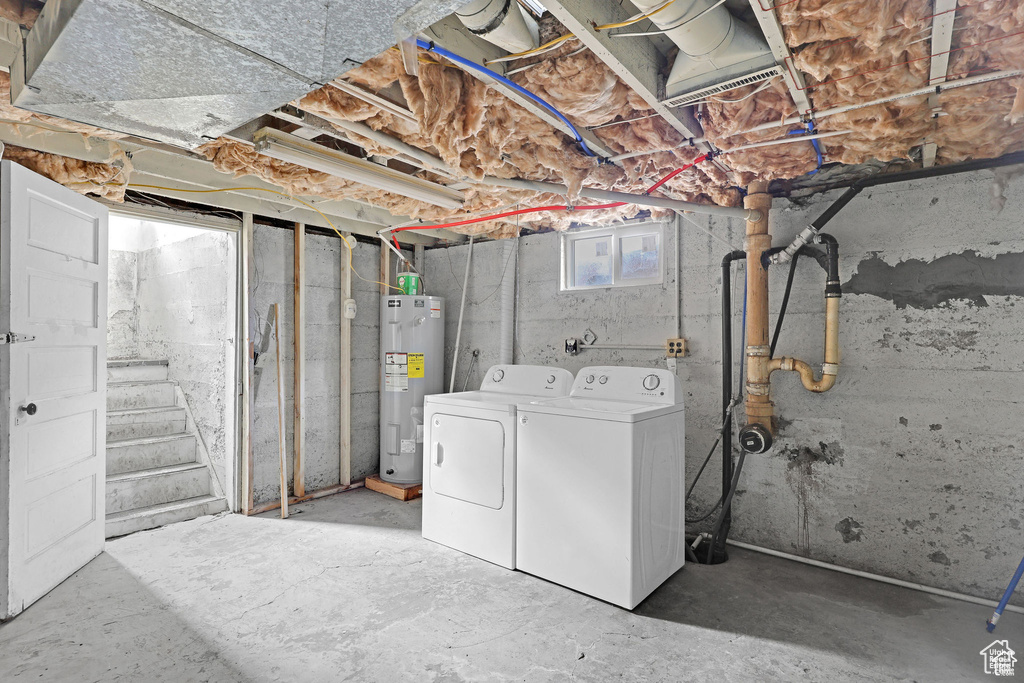 Basement featuring electric water heater, washing machine and dryer, and stairway