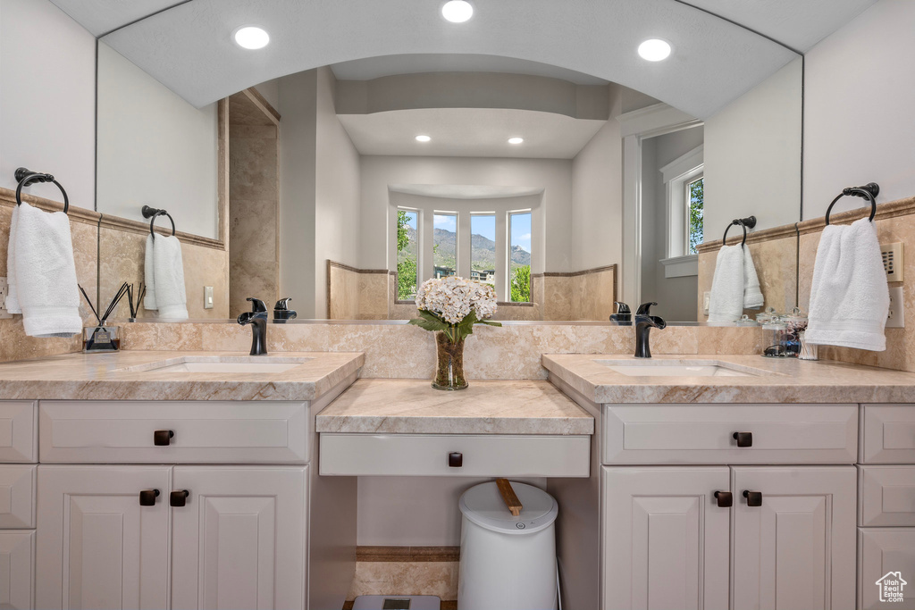 Bathroom with healthy amount of natural light, recessed lighting, and vanity