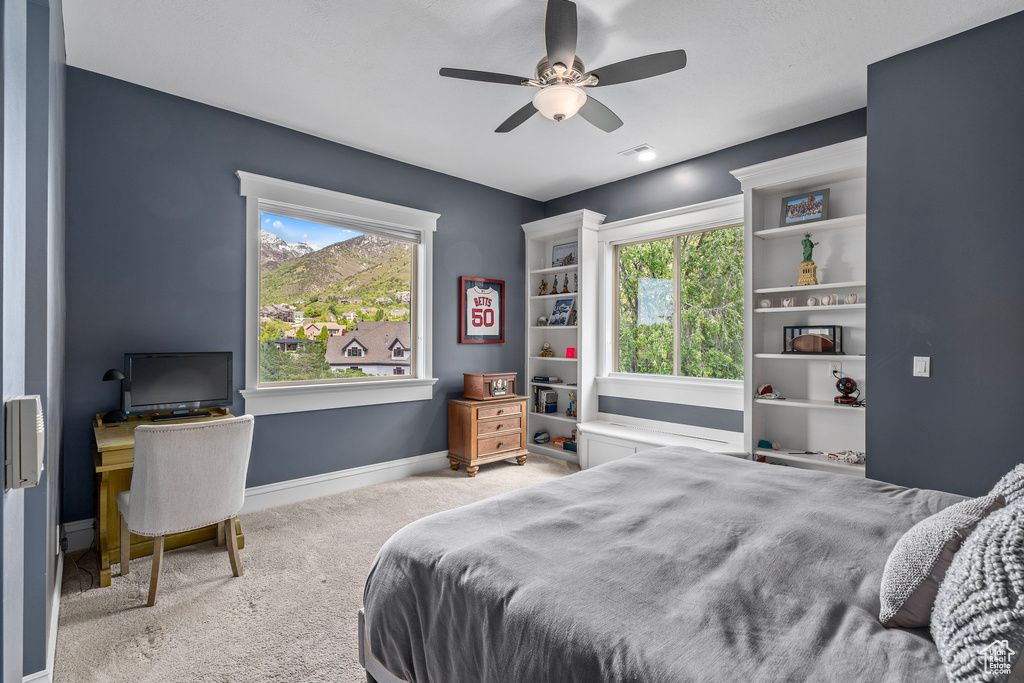 Carpeted bedroom with baseboards and a ceiling fan