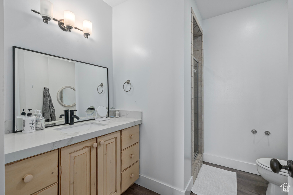 Bathroom featuring toilet, baseboards, and wood finished floors