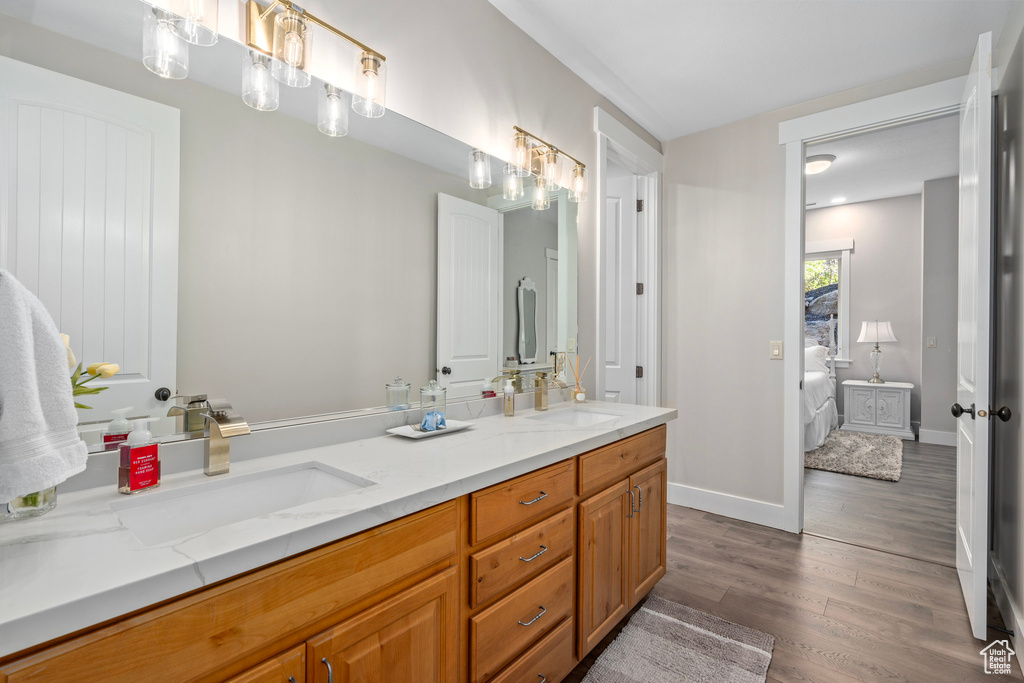 Full bath with wood finished floors, ensuite bathroom, double vanity, and baseboards