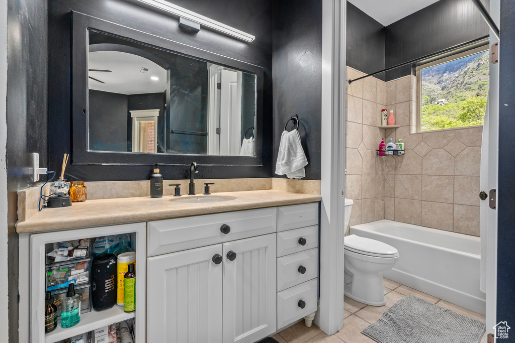 Full bath featuring tile patterned floors, toilet, vanity, and washtub / shower combination