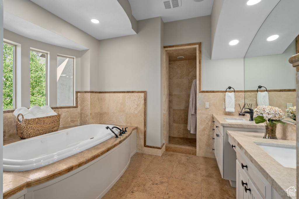 Full bathroom with vanity, a garden tub, a stall shower, and recessed lighting