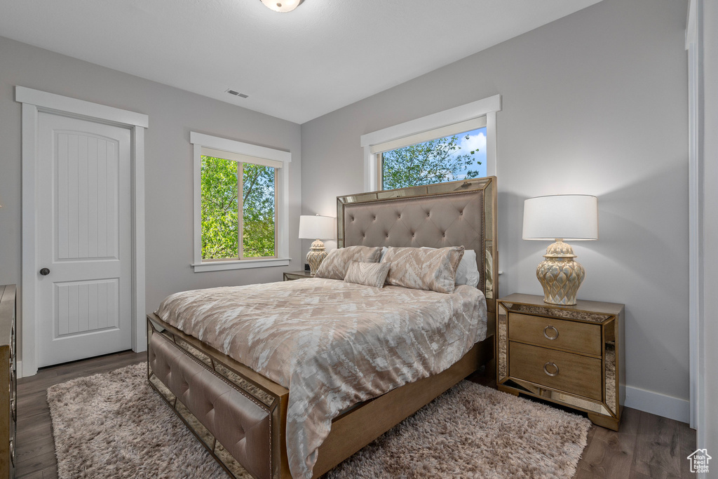 Bedroom with wood finished floors and baseboards