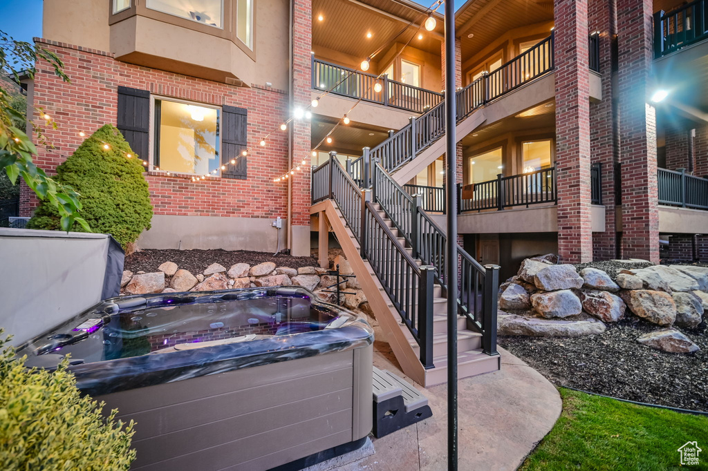 View of patio with a hot tub and stairway