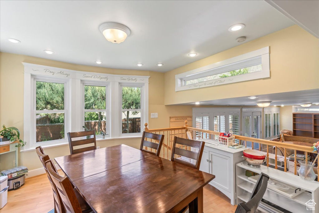 Dining room with light wood finished floors and recessed lighting