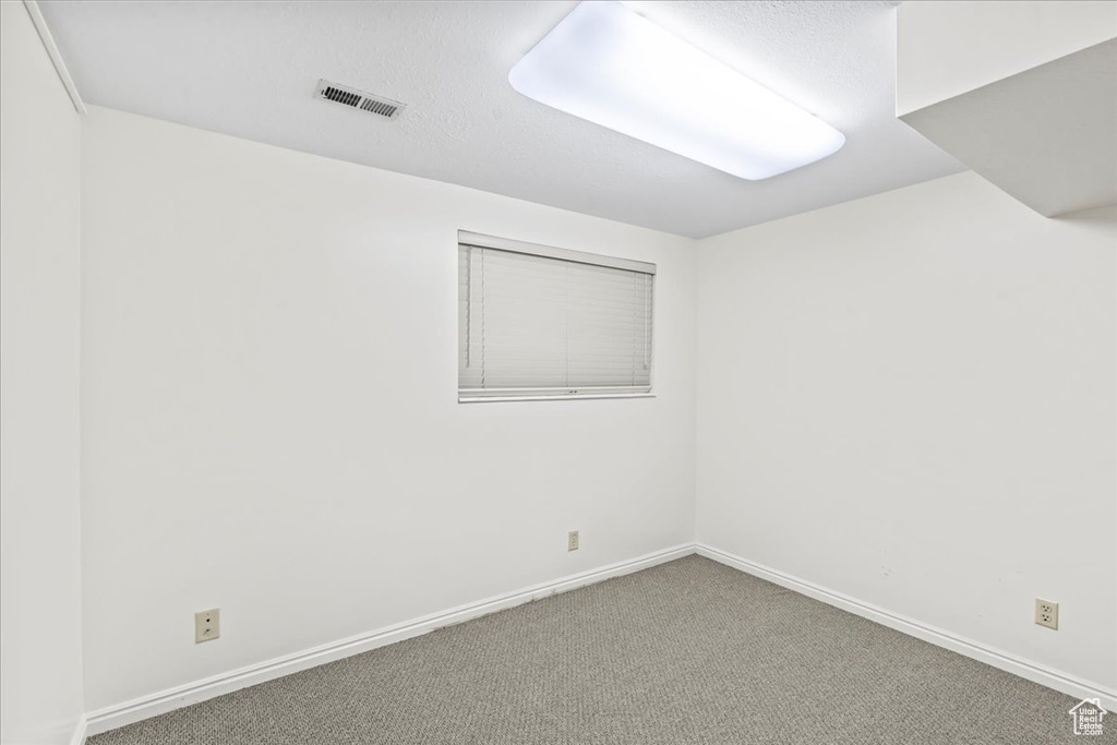 Spare room with carpet and baseboards