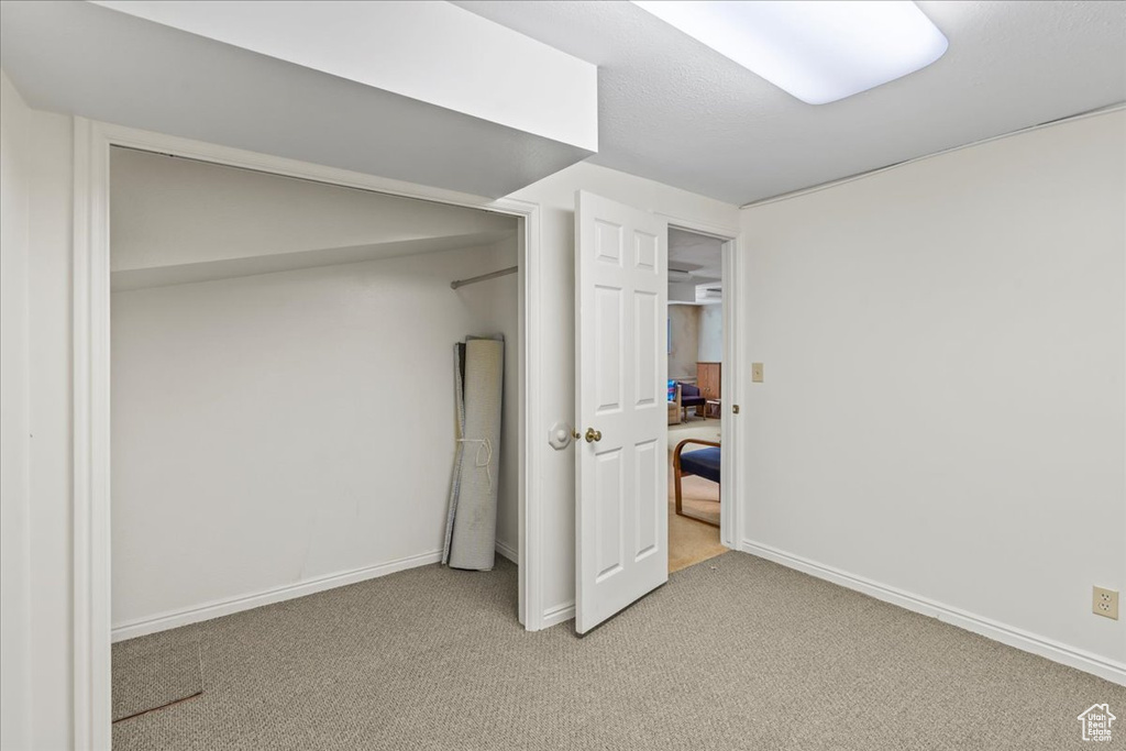 Below grade area with light carpet and baseboards