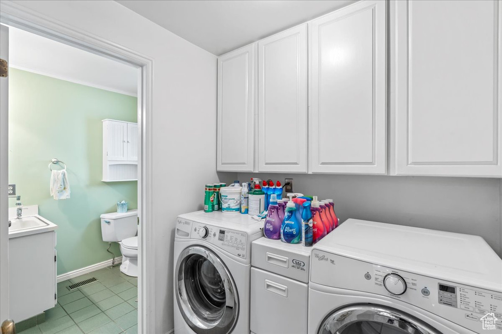 Washroom featuring independent washer and dryer, baseboards, light tile patterned floors, and a sink