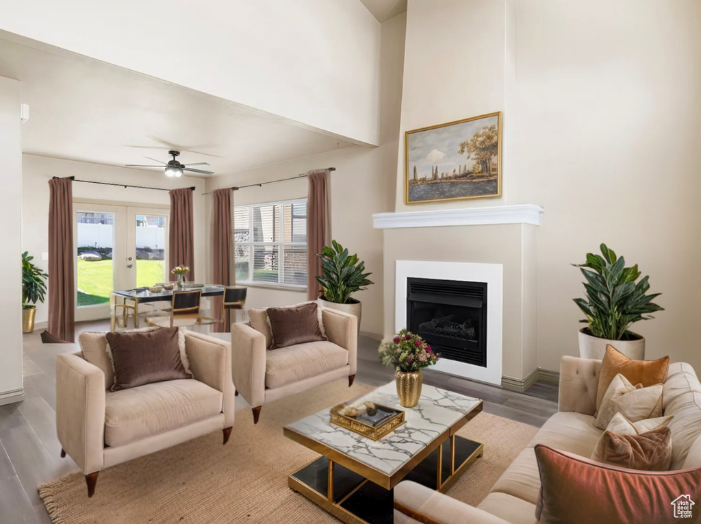 Living room with a ceiling fan, french doors, a fireplace, and wood finished floors