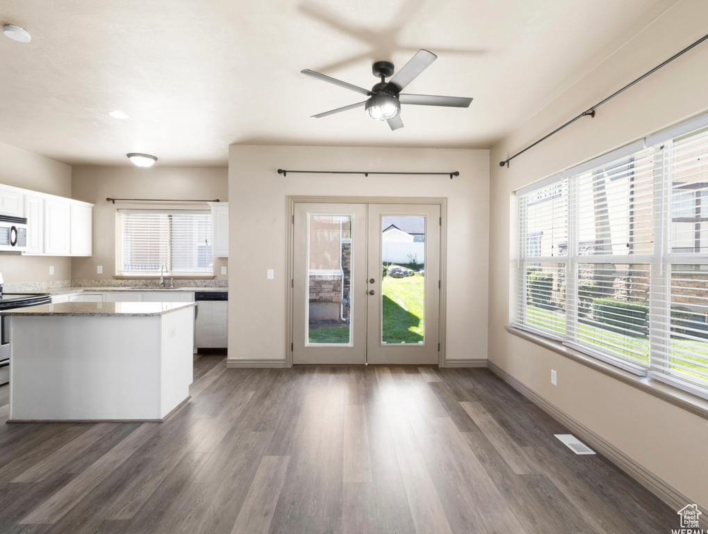 Kitchen with french doors, a sink, stainless steel appliances, white cabinetry, and ceiling fan