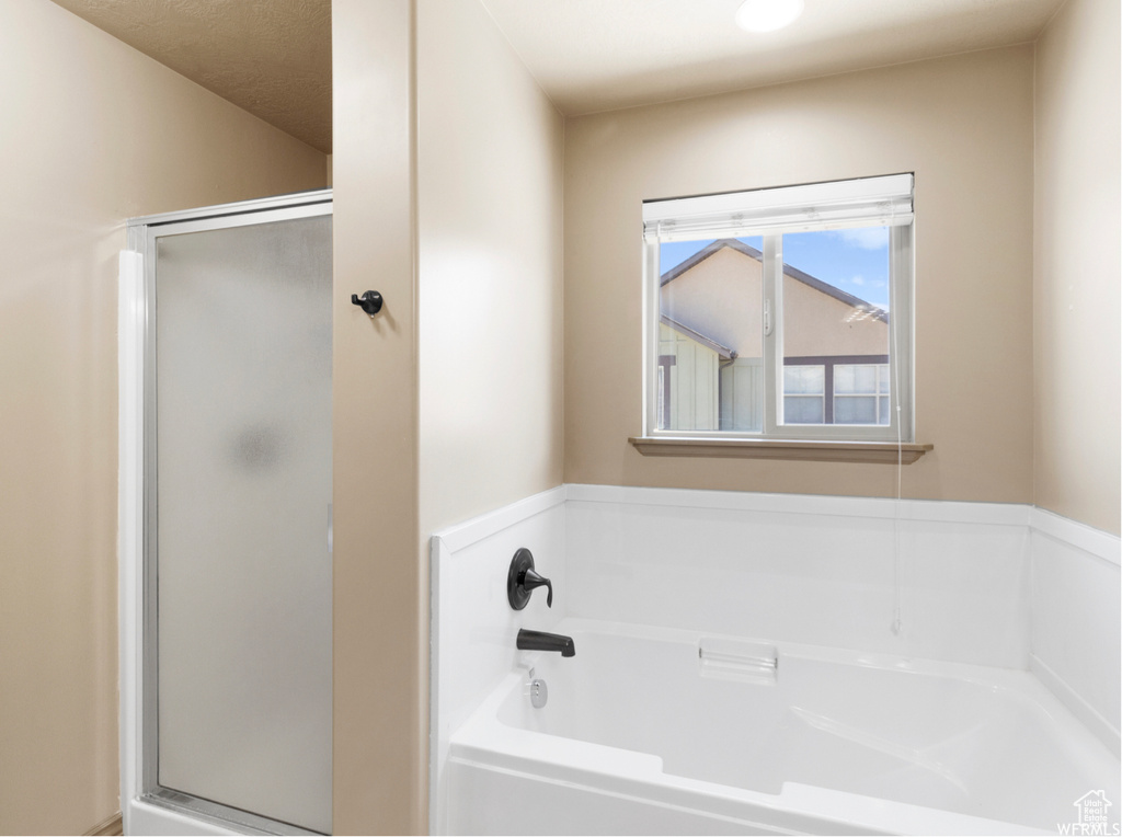 Full bath with a shower stall and a bath