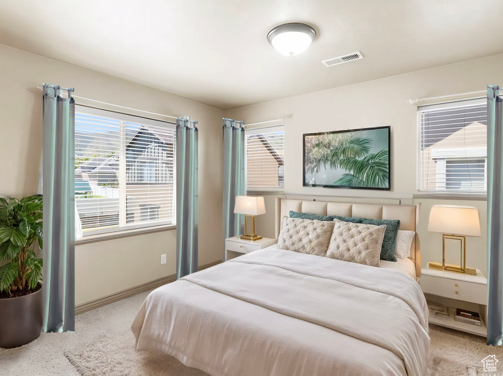 Carpeted bedroom featuring baseboards and visible vents