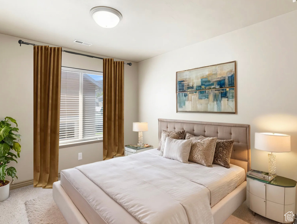 Bedroom with baseboards, visible vents, and light colored carpet