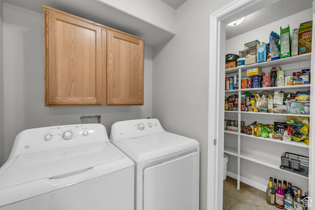 Washroom featuring washer and dryer and cabinet space