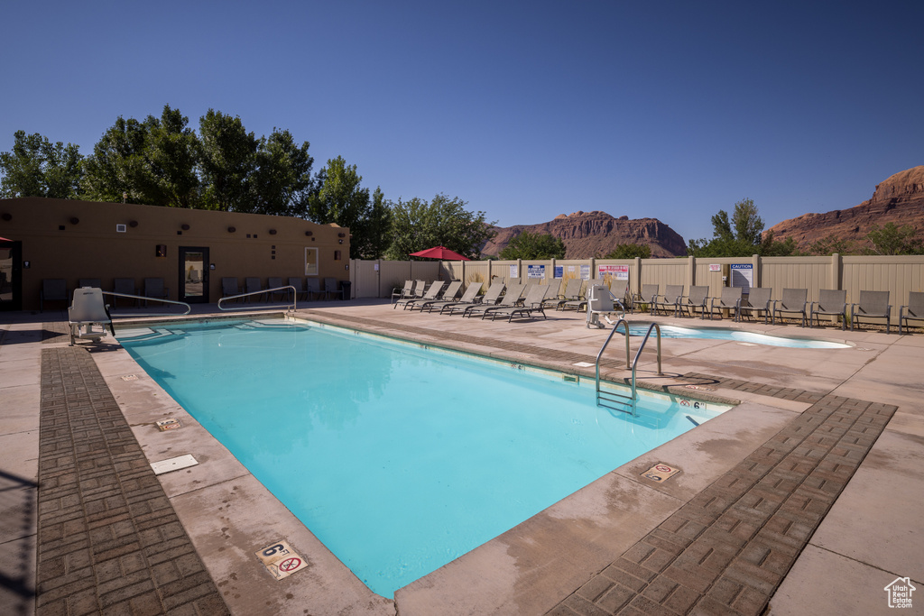 Community pool featuring a mountain view, a patio area, and fence