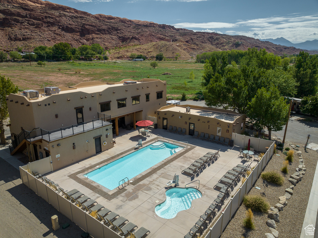 Community pool with a mountain view, a patio area, and fence