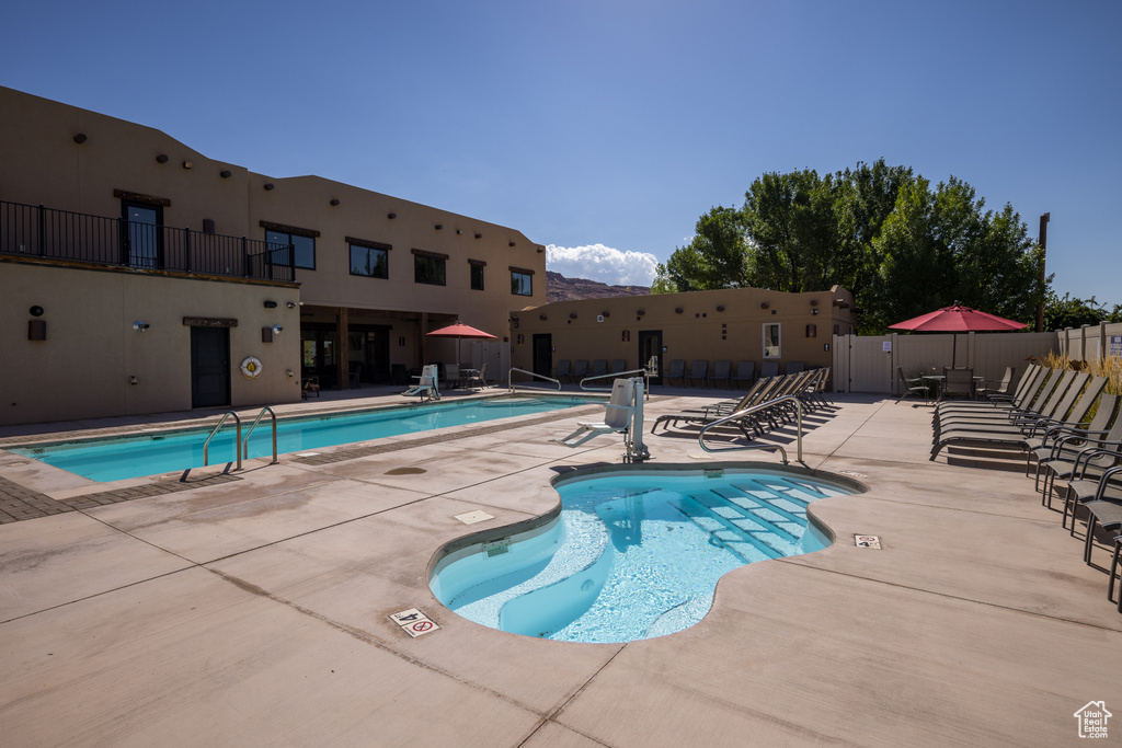 Community pool featuring a patio area and fence