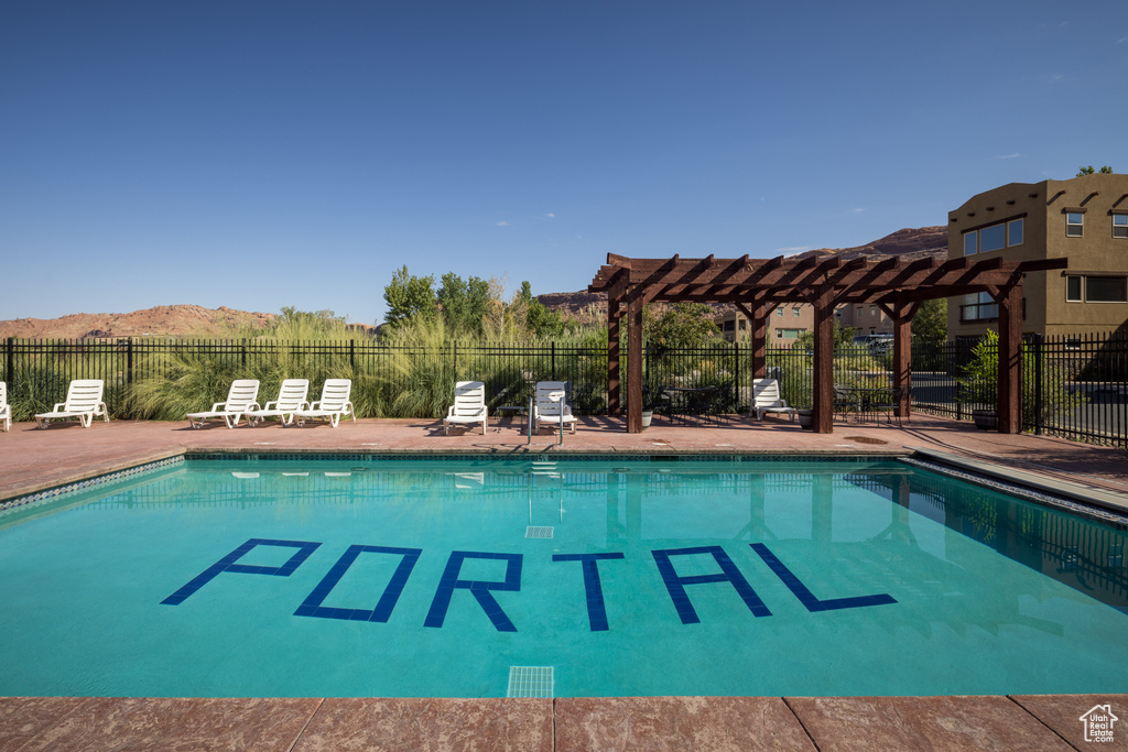 Community pool with a pergola, fence, a mountain view, and a patio area