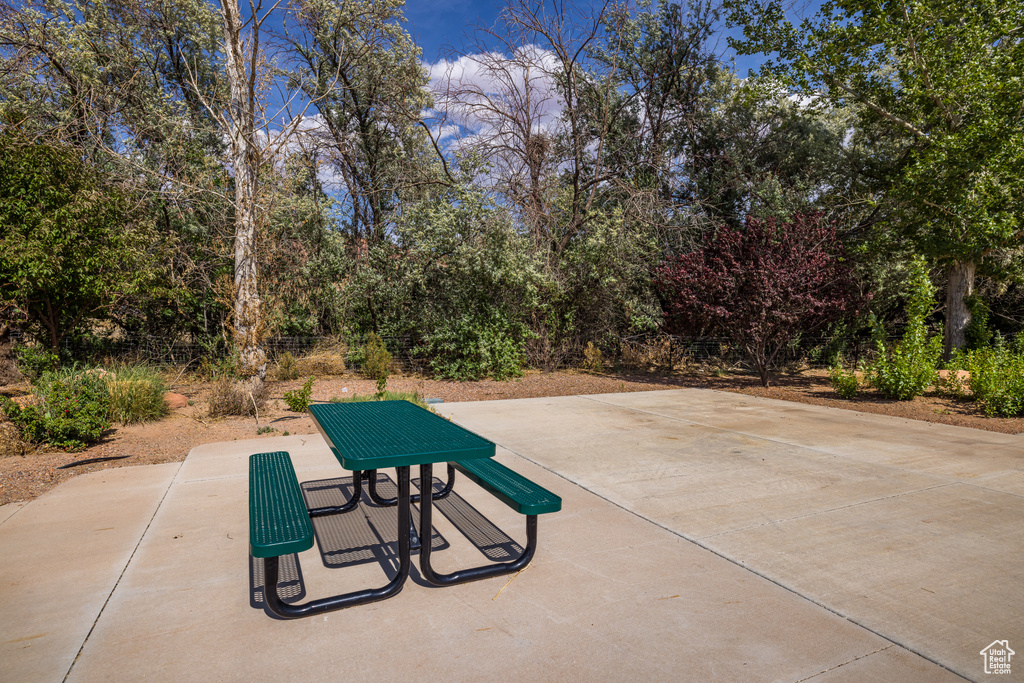 Surrounding community featuring a patio area and view of wooded area
