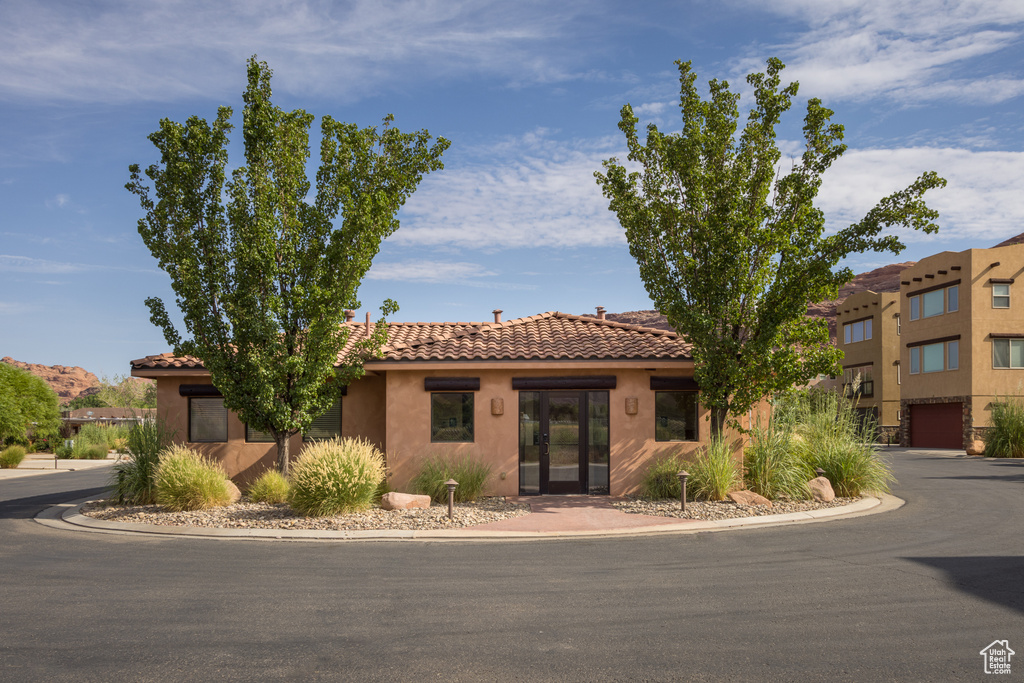 View of front of property featuring stucco siding and a tile roof