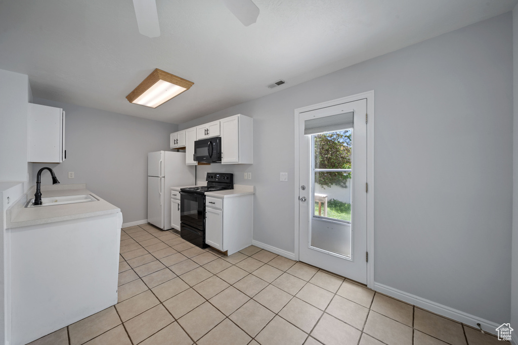 Kitchen featuring black appliances, a sink, light countertops, white cabinets, and light tile patterned flooring