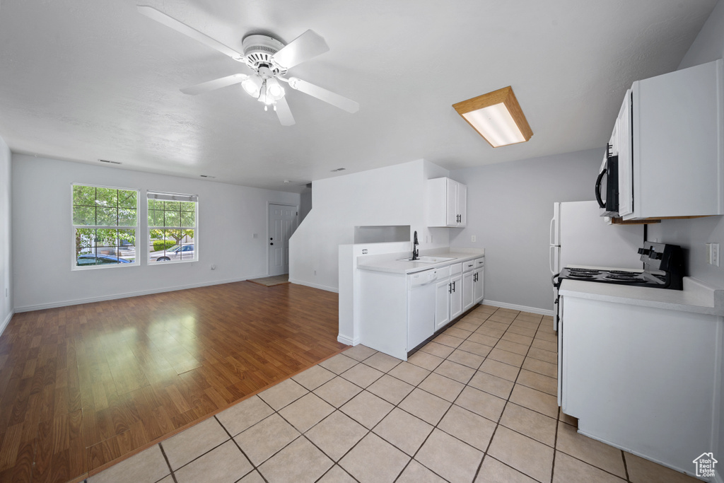 Kitchen with a sink, open floor plan, range with electric cooktop, light countertops, and dishwasher