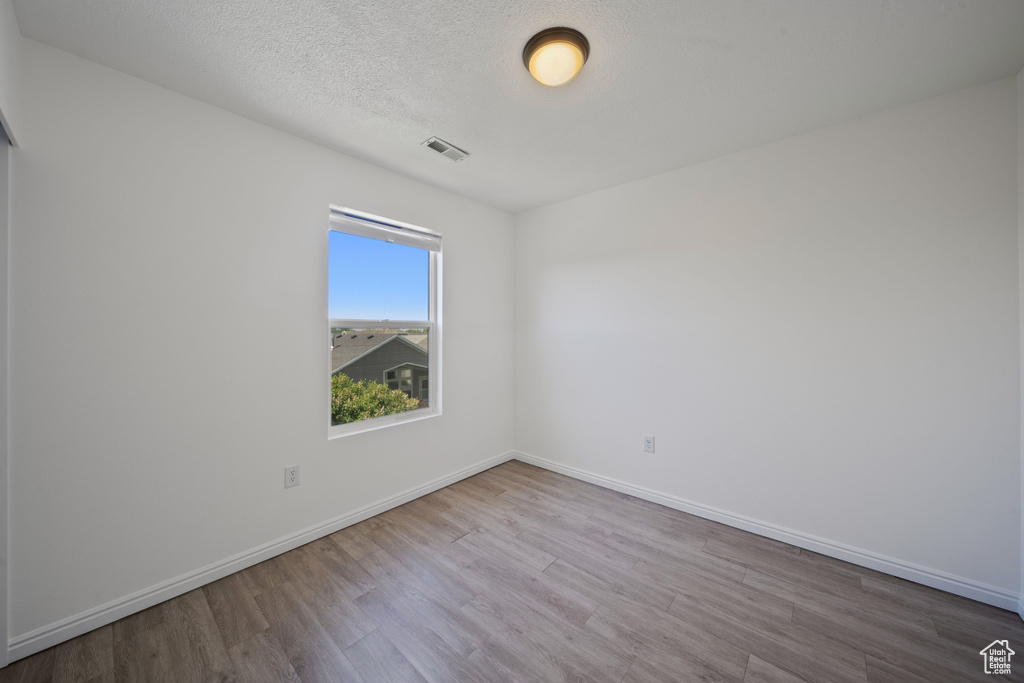 Spare room featuring wood finished floors and baseboards