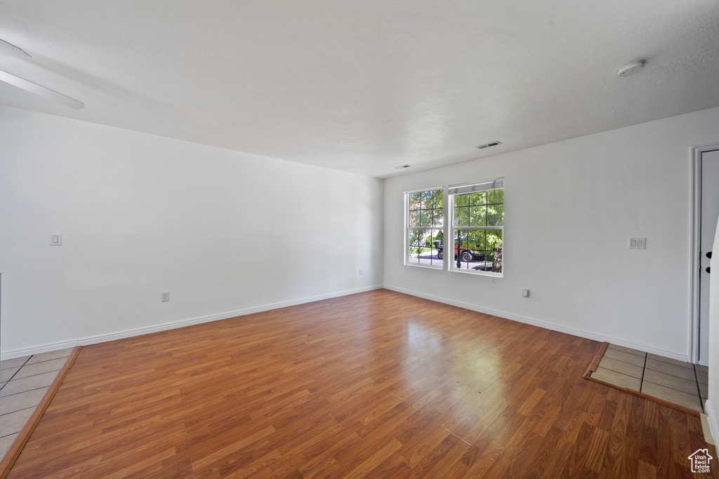 Unfurnished room featuring wood finished floors, a smoke detector, and baseboards