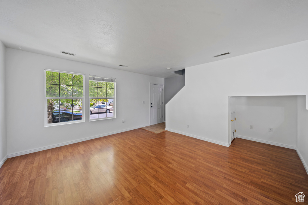 Unfurnished living room with wood finished floors and baseboards