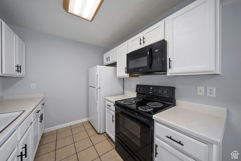 Kitchen featuring black appliances, white cabinetry, baseboards, light countertops, and light tile patterned flooring