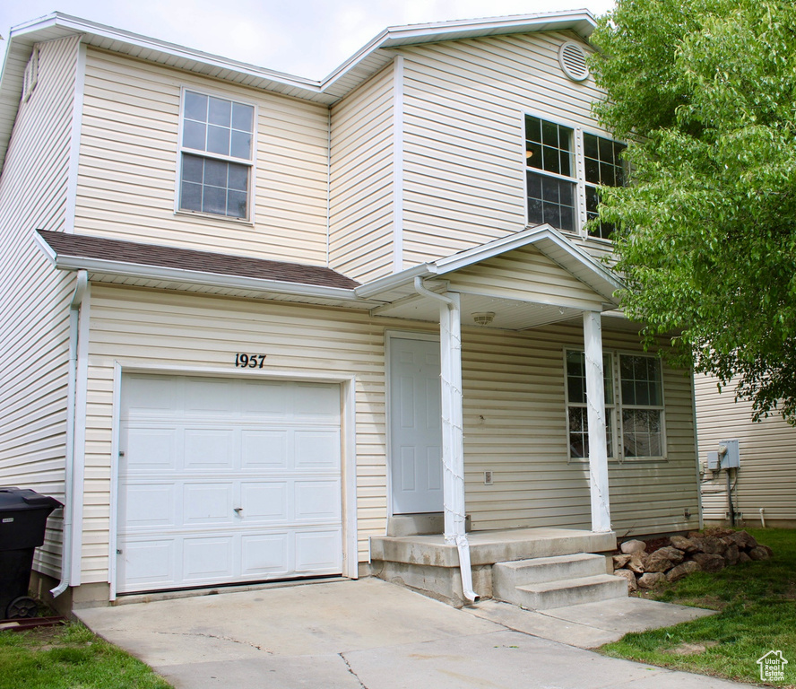 View of front of house with a garage, covered porch, and driveway