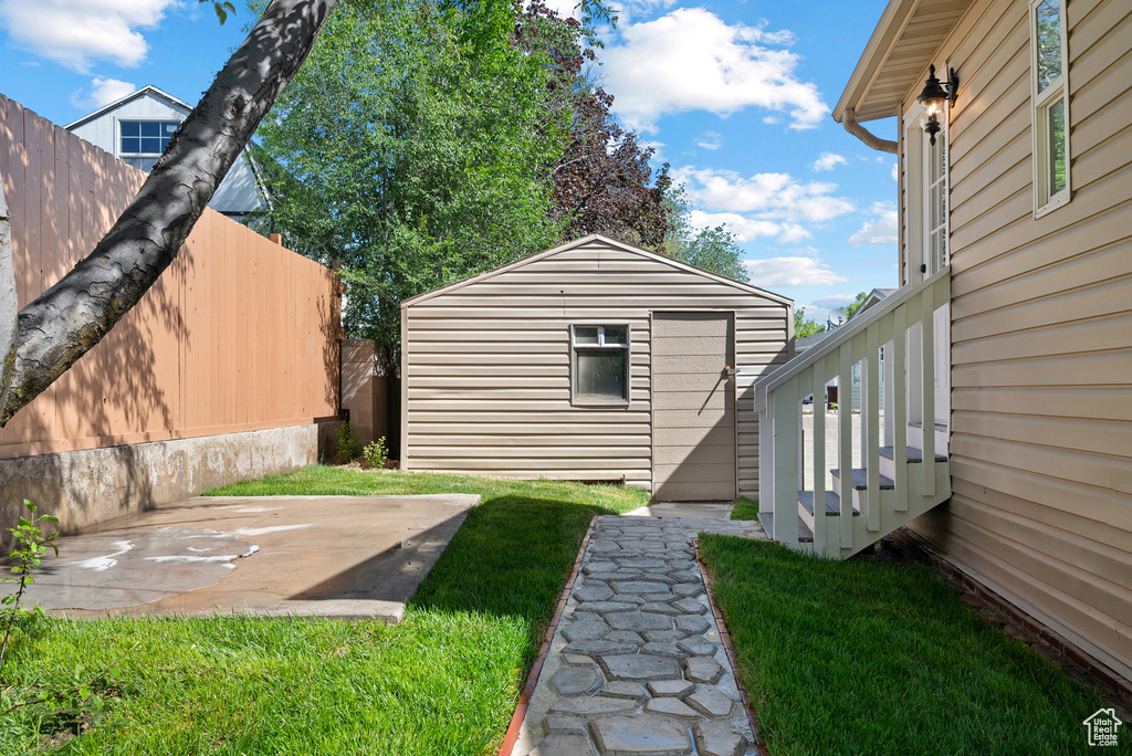 View of yard with an outdoor structure and a patio