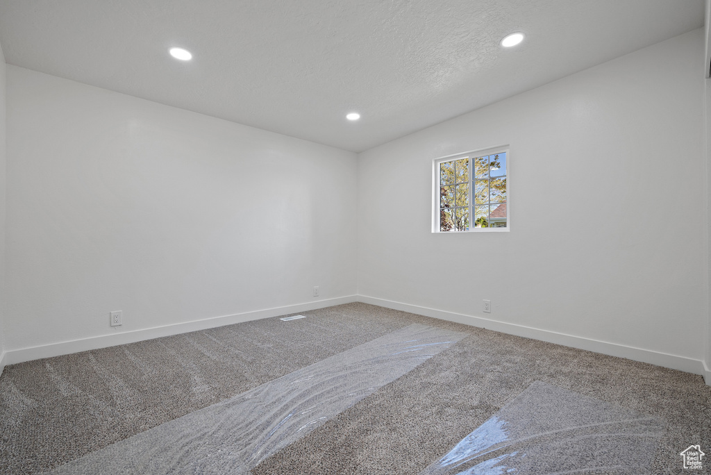 Carpeted spare room with recessed lighting and baseboards