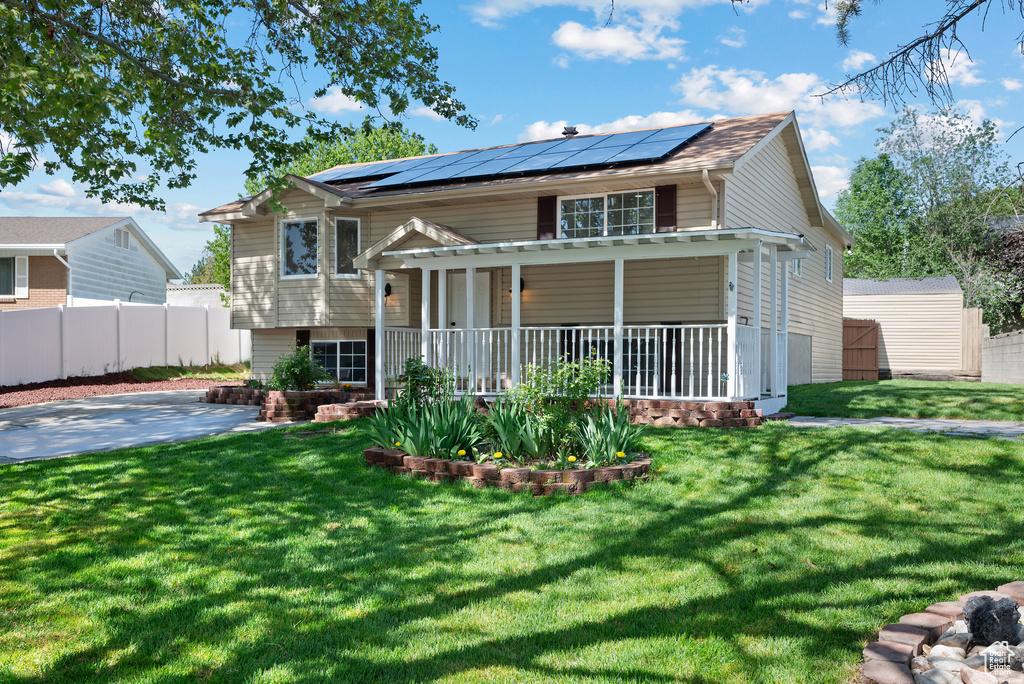 View of front facade with covered porch and solar panels