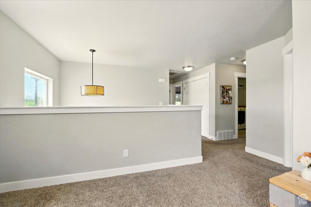 Spare room featuring carpet flooring, baseboards, and washer / clothes dryer