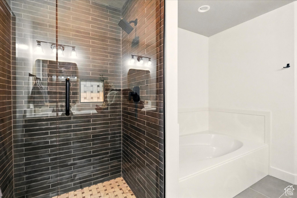Full bath featuring a bath, tiled shower, and tile patterned floors