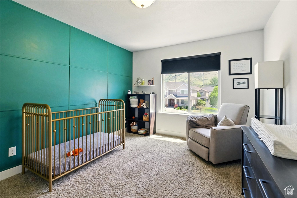 Bedroom featuring carpet floors and a nursery area