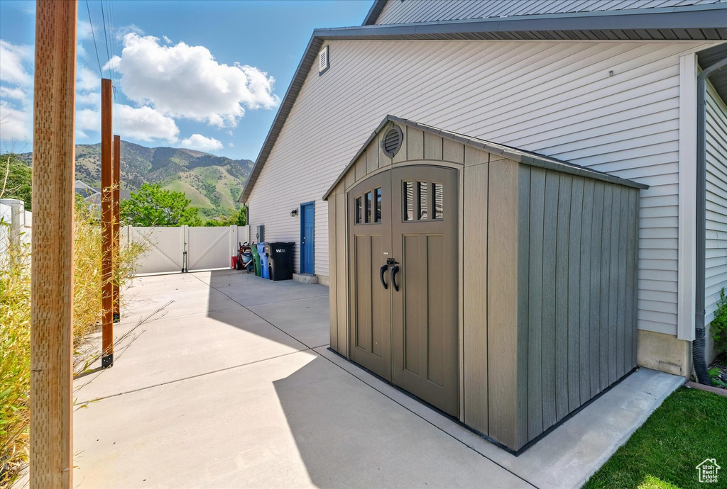 View of shed with a gate, a mountain view, and fence