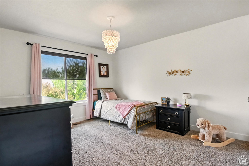Bedroom with a chandelier, carpet floors, and baseboards
