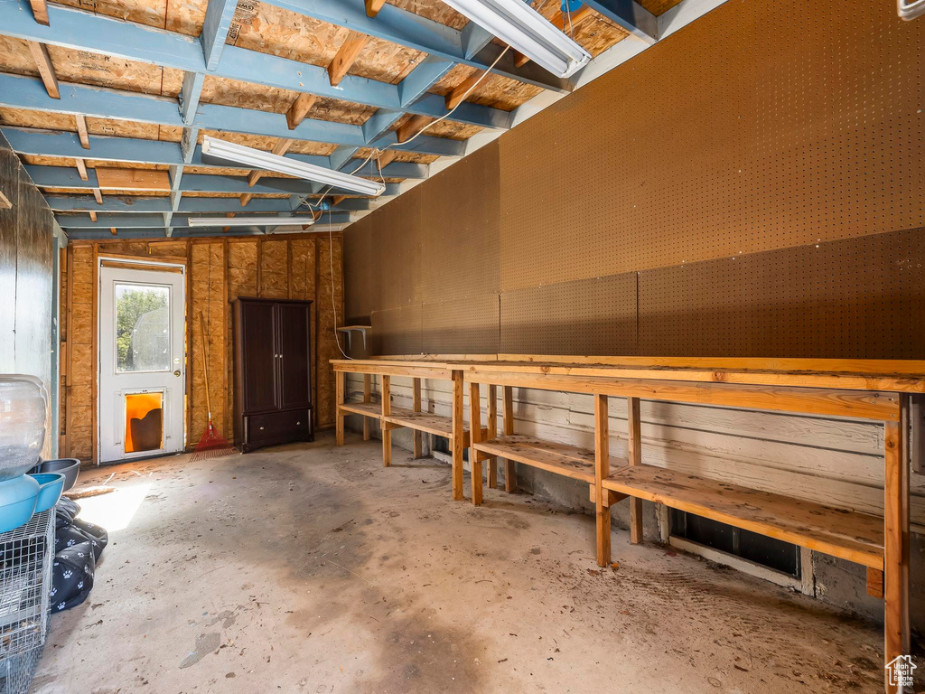 Misc room with concrete flooring and a workshop area