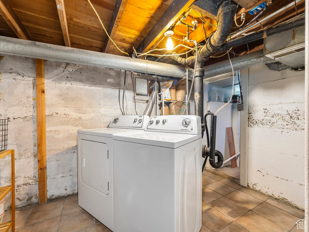 Laundry area with washer and clothes dryer and tile patterned flooring