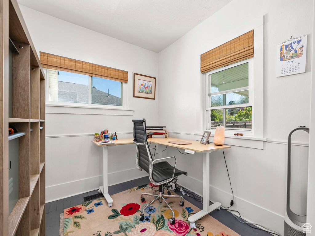 Office with healthy amount of natural light, wood finished floors, and baseboards